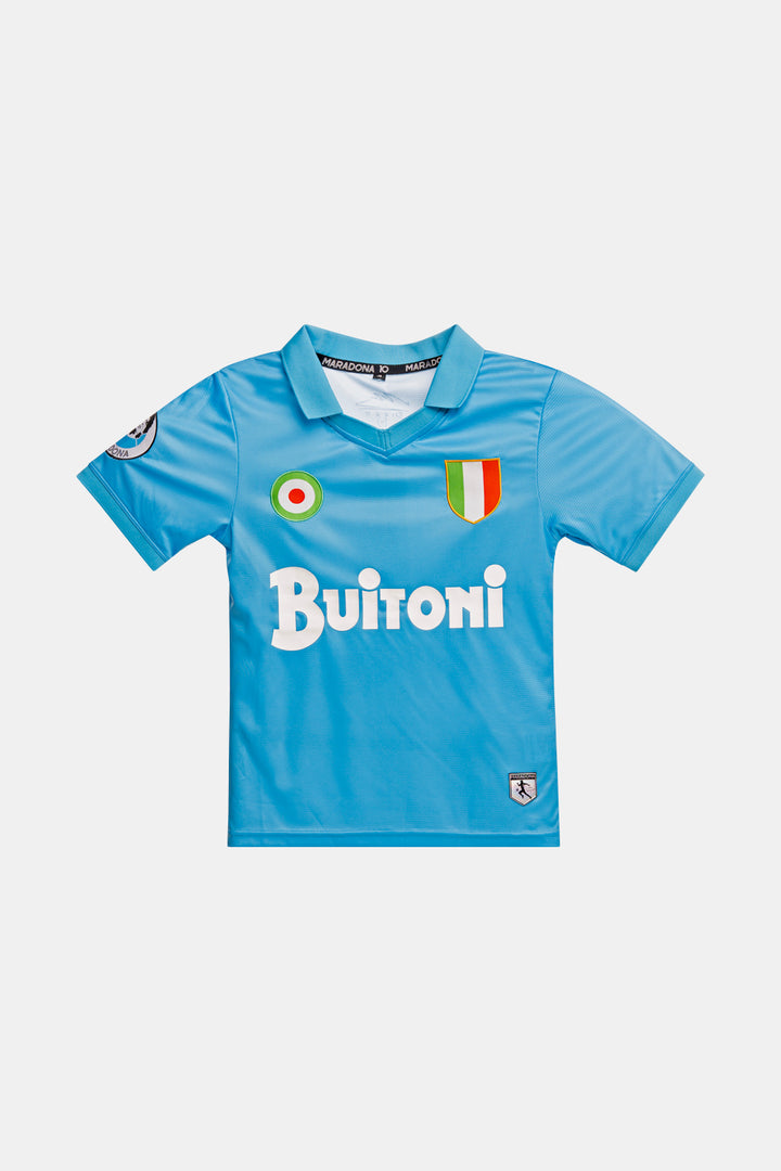 A light blue short-sleeve soccer jersey with 'Buitoni' in white across the chest, an Italian flag crest on the right chest, and a circular green, white, and red emblem on the left chest, shown on a light gray background.