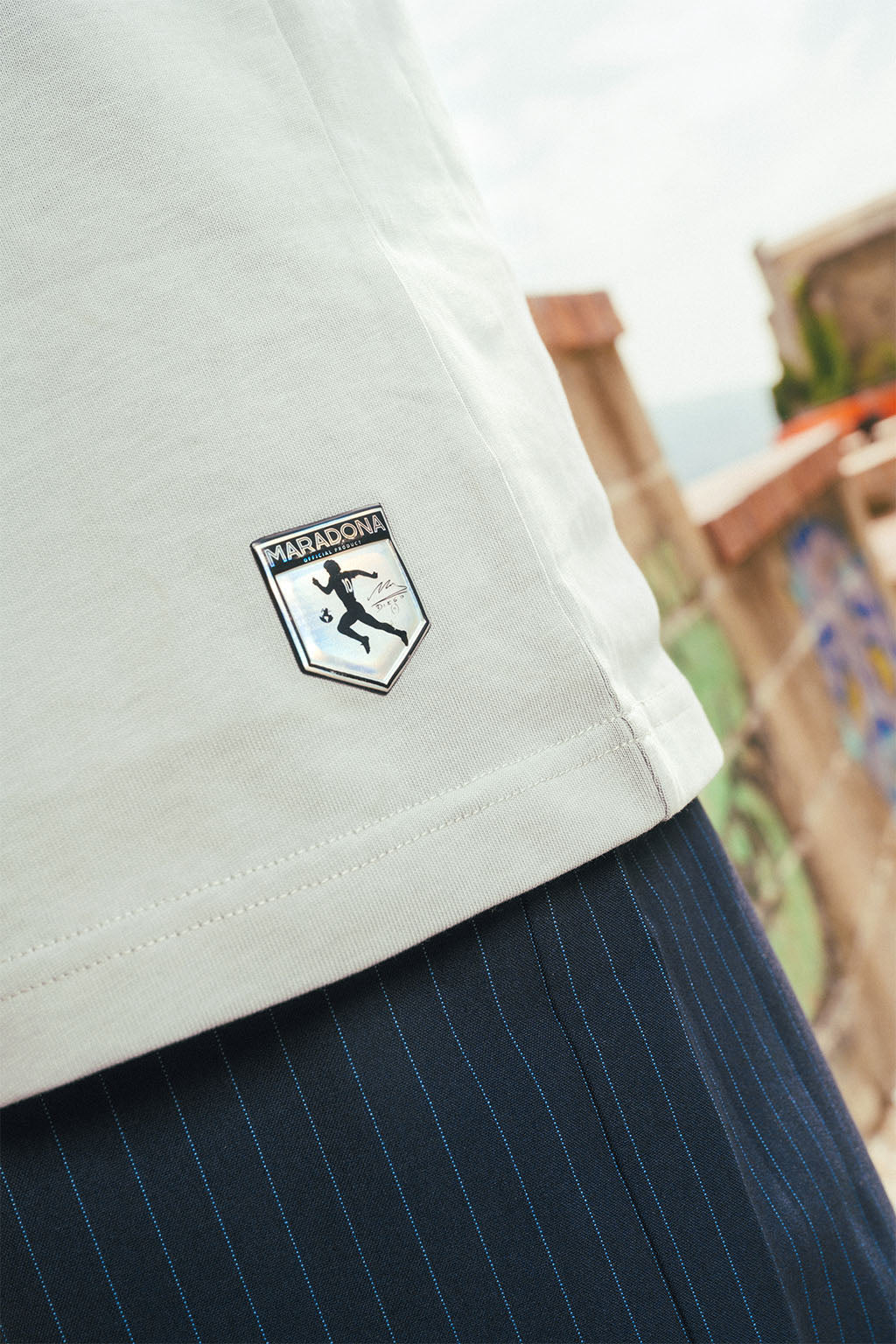 Close-up of a ash grey shirt with a Maradona logo and, blurred background