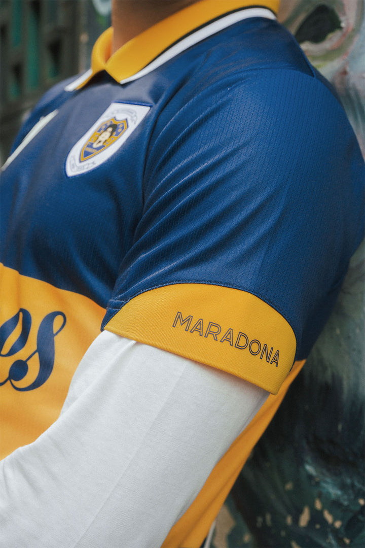 Close-up of a Boca jersey with 'Maradona' branding on a blurred background